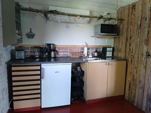 a small kitchen with a counter and a refrigerator at B&B Klarälvsbanan in Deje