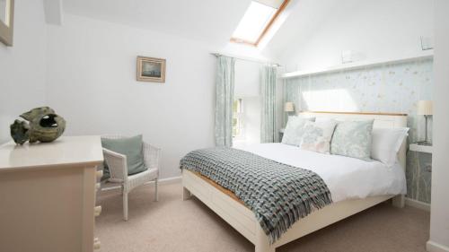 een slaapkamer met een bed, een bureau en een stoel bij Budle Bay Loft in Bamburgh