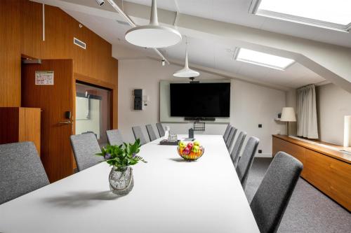 a conference room with a table and chairs and a tv at Best Western Plus Sthlm Bromma in Stockholm