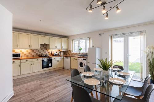 una cucina con tavolo e sedie e una sala da pranzo di Lovely 4 Bedroom Home w Parking Near Doncaster a Askern