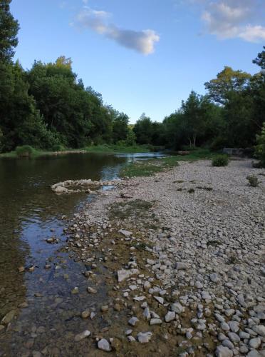 une rivière avec des rochers et des arbres en arrière-plan dans l'établissement Le chalet dans les bois, à Lecques
