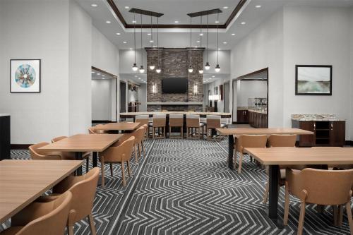a dining room with tables and chairs and a tv at Homewood Suites by Hilton Seattle/Lynnwood in Lynnwood