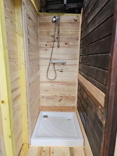 - un sauna avec une douche dans un mur en bois dans l'établissement Le chalet dans les bois, à Lecques