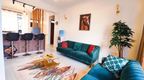 Una sala de estar con un sofá azul y una mesa. en Heri Ngong Heights --- Garden, Parking, Stable WiFi, Security, en Ngong