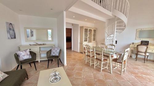 un salon avec une table et une salle à manger dans l'établissement Les Tropéziennes - Chic Triplex Balcon Vue Marina, à Cogolin