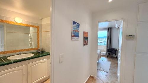 La salle de bains est pourvue d'un lavabo et d'un miroir. dans l'établissement Les Tropéziennes - Chic Triplex Balcon Vue Marina, à Cogolin