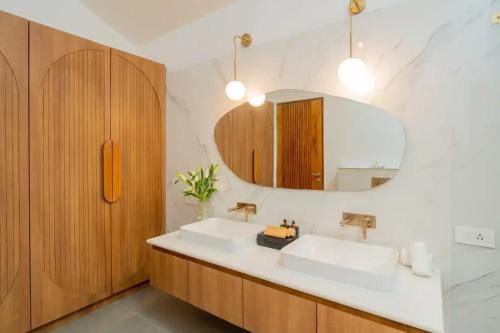 un bagno con due lavandini e uno specchio di Villa Arcadia by AT Villas - 3 BHK with Outdoor pool a Vagator