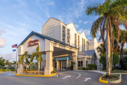 a hotel with palm trees in front of it at Hampton Inn & Suites Fort Lauderdale Airport in Hollywood