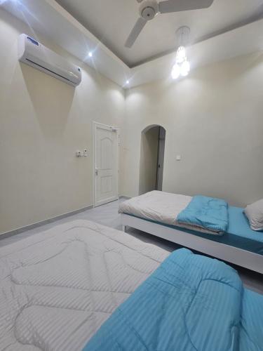 a bedroom with two beds and a blue mattress at White Mountain House in Sharīyah