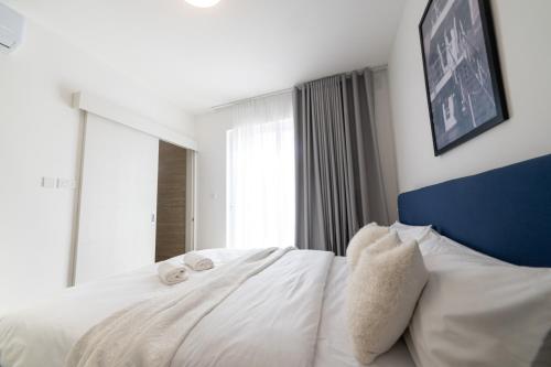 a bedroom with a white bed with towels on it at Luxury Apartment Valley Views A8 in Xagħra