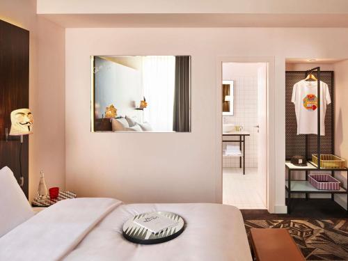a bedroom with a bed and a mirror on the wall at Mama Shelter Prague in Prague