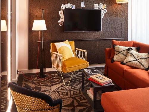 a living room with two chairs and a tv at Mama Shelter Prague in Prague