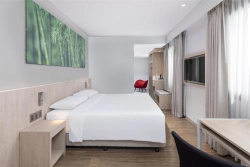 a bedroom with a large white bed and a red chair at Park Inn by Radisson North Edsa in Manila