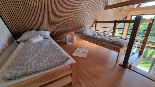 two beds in a room with a window at Jodłowe Zacisze in Lubkowo