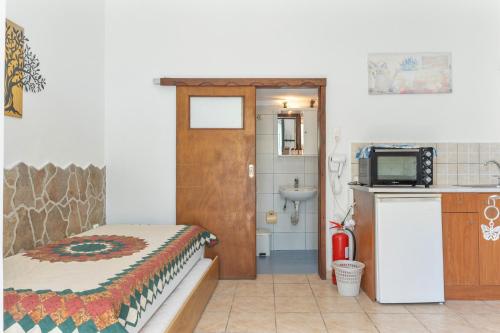 a room with a bed and a bathroom with a sink at Mouria Studio 4 in Kithnos