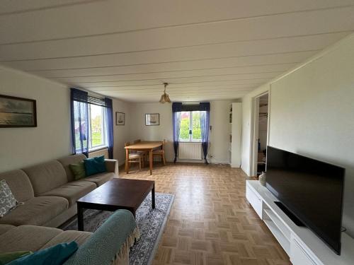a living room with a couch and a flat screen tv at Patterdale farm holiday apartments in Gamleby