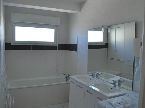 La salle de bains est pourvue de 2 lavabos, d'une baignoire et d'une fenêtre. dans l'établissement Appartement moderne 2 chambres, balcon plage, animaux admis - FR-1-482-158, à Fort-Mahon-Plage