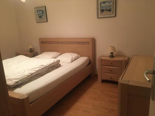- une chambre avec un lit, une commode et une table de nuit dans l'établissement Appartement moderne 2 chambres, balcon plage, animaux admis - FR-1-482-158, à Fort-Mahon-Plage