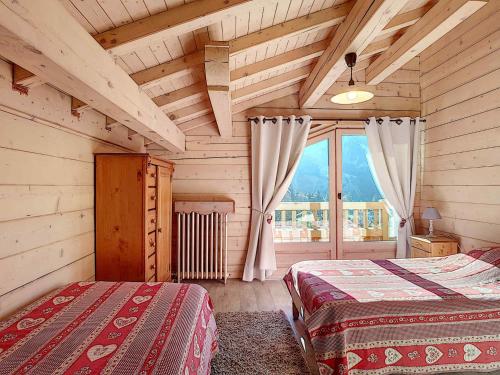 une chambre avec deux lits et une grande fenêtre dans l'établissement Chalet cosy à La Clusaz, 9 personnes, parking - FR-1-818-105, à La Clusaz