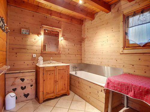 une salle de bain avec une baignoire et un lavabo dans l'établissement Chalet cosy à La Clusaz, 9 personnes, parking - FR-1-818-105, à La Clusaz