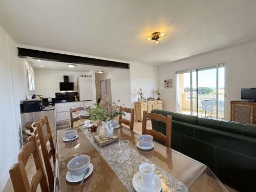 - un salon avec une table et un canapé vert dans l'établissement Magnifique Villa T5 Proche Plage & Commerces - 8 Pers - Saint-Pierre-La-Mer - FR-1-795-68, à Fleury