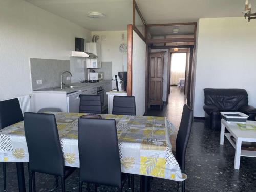 une cuisine et une salle à manger avec une table et des chaises dans l'établissement Appartement face mer climatisé avec parking au Grau-du-Roi - FR-1-731-141, au Grau-du-Roi