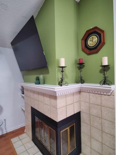 a fireplace with a clock on a green wall at Mandarin I95 2 bedrooms Quiet area Backyard in Jacksonville
