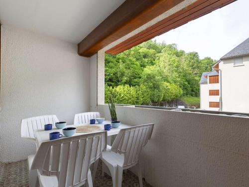 un balcon avec une table, des chaises et une fenêtre dans l'établissement Studio confortable près téléphérique, garage privé - FR-1-296-521, à Saint-Lary-Soulan