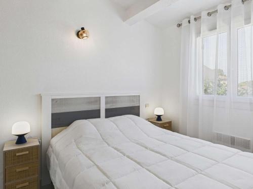 une chambre blanche avec un grand lit et une fenêtre dans l'établissement Maison 3 chambres climatisée proche plage - FR-1-423-327, au Grau-dʼAgde