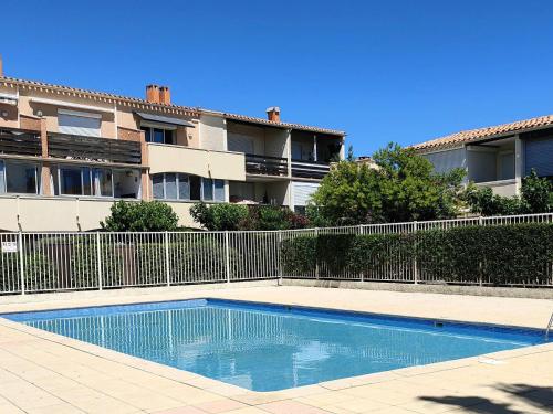 une piscine devant un immeuble dans l'établissement Joli T2 cabine climatisé au Cap d'Agde, piscine et parking, proche mer - FR-1-607-221, au Cap d'Agde