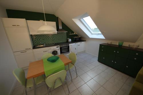 a kitchen with a table and some green chairs at Köln-Kerpen Boutique-Ferienwohnungen Angela & Maurizio in Kerpen