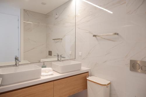 a white bathroom with a sink and a mirror at T3 Baía de São Martinho in São Martinho do Porto