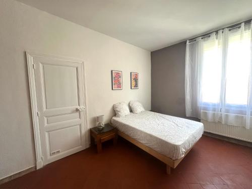 - une chambre avec un lit, une porte et une fenêtre dans l'établissement Centre ville, grand T3 avec balcon, à Narbonne
