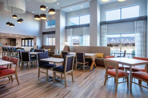 a restaurant with tables and chairs and windows at Hampton Inn & Suites La Grande, Or in La Grande