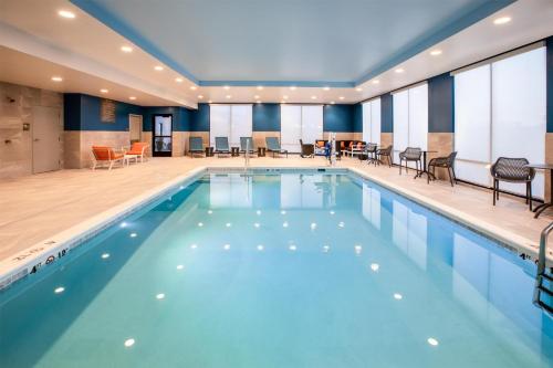 a pool in a hotel with chairs and tables at Hampton Inn & Suites La Grande, Or in La Grande