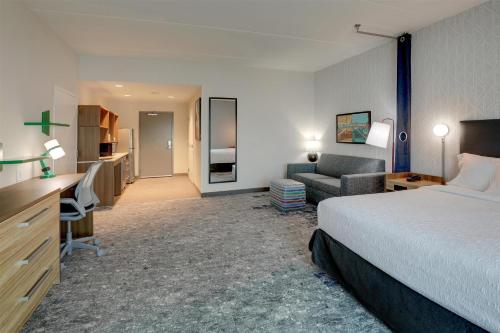 a hotel room with a bed and a desk and a couch at Home2 Suites By Hilton Conway, Sc in Conway
