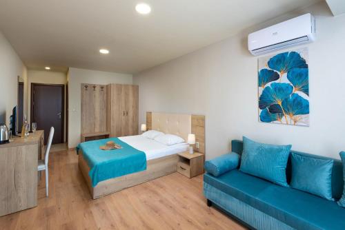 a bedroom with a bed and a blue couch at Sea View Hills in Sveti Vlas