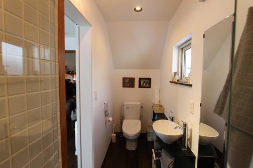 a small bathroom with a toilet and two sinks at Forest Hideaway in Niseko