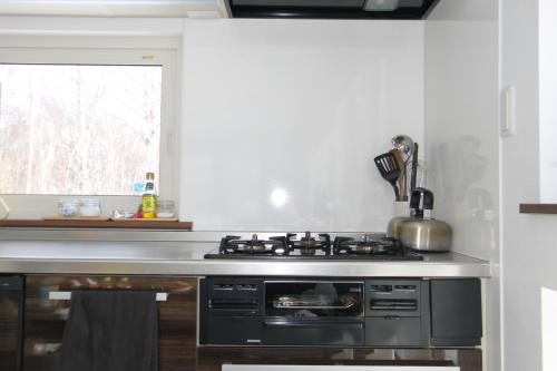 a kitchen with a stainless steel stove top oven at Forest Hideaway in Niseko