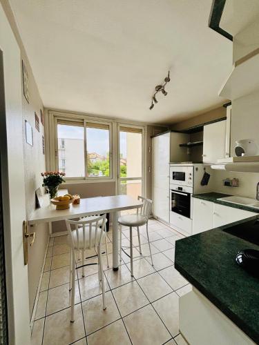 une cuisine avec une table et quelques chaises dans l'établissement T3 lumineux, parking privé, calme, jolie vue, à Saint-Étienne