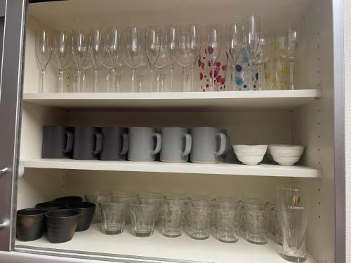 a cupboard filled with lots of glasses and bowls at Lake England 富士山が見える隠れ家ロッジ in Fujikawaguchiko