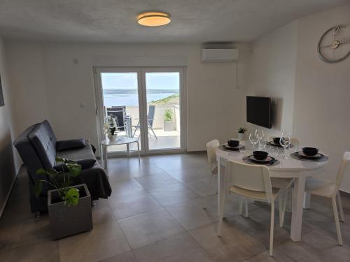 sala de estar con mesa y comedor con vistas al océano en Apartment Monika Maslenica, en Maslenica