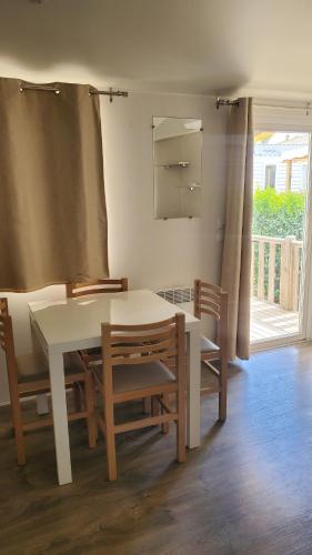 une salle à manger avec une table et des chaises blanches dans l'établissement Mobilhomelaco34siblu, à Valras-Plage
