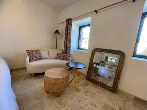 - un salon avec un miroir et un canapé dans l'établissement La Métairie du Château Paul, à Aussillon