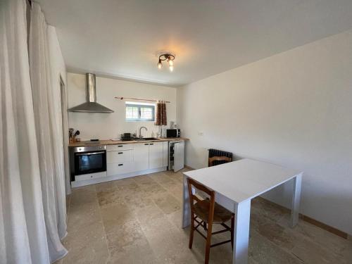 une cuisine avec une table blanche et un comptoir blanc dans l'établissement La Métairie du Château Paul, à Aussillon