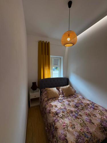 a bedroom with a bed and a yellow curtain at Goździkowy Apartament in Frombork