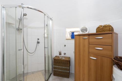 チステルニーノにあるTrullo Antica Pietraのバスルーム(シャワー付)、木製キャビネットが備わります。