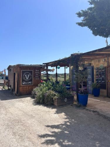 a building with a sign and plants in front of it at Ta Skorba Farmhouse Mgarr in Mġarr
