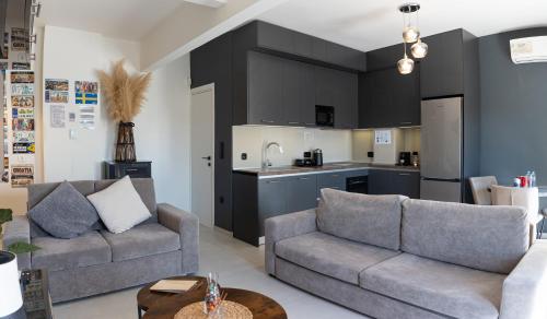 a living room with two couches and a kitchen at Thessaloniki Gem -1 min from Metro - Brand New Flat with View - Ολοκαίνουργιο Διαμέρισμα Με Θέα!! in Thessaloniki