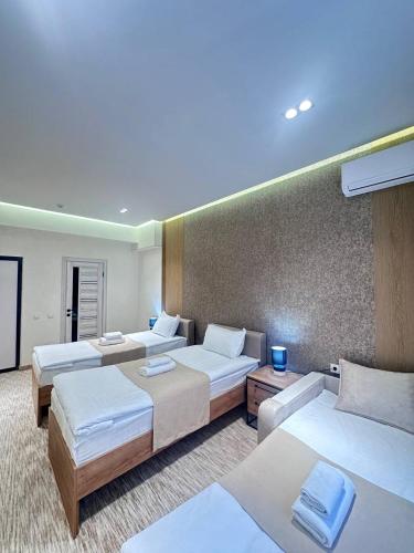 a hotel room with three beds and avisor at North Star Hotel in Yakkasaray